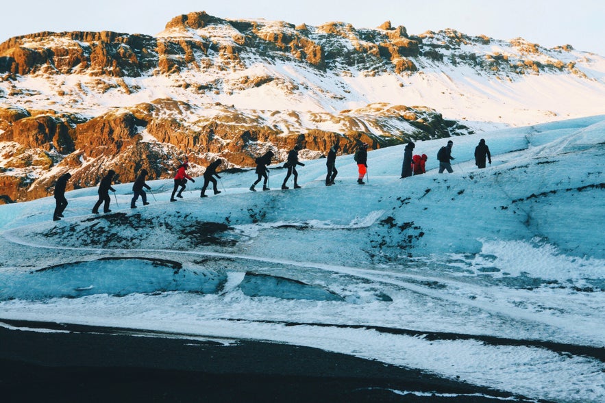 Randonneurs en ligne lors de leur randonnée sur glacier au Solheimajökull.