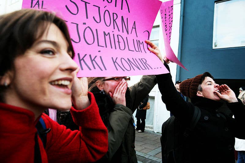 People at a gender-equality demonstration in Reykjavik holding a pink protest sign
