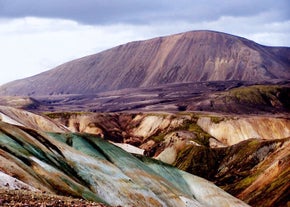 Landmannalaugar in the Icelandic Highlands is known for its striking rainbow-colored rhyolite mountains, streaked with shades of yellow, red, green, pink, and blue.