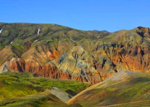 The rugged mountains at Landmannalaugar in the Icelandic Highlands are colored in vibrant greens, reds, and yellows, a photographer’s dream.
