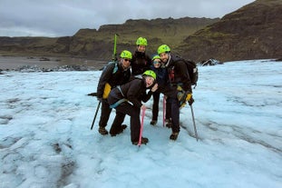 A group of adventurers posing atop the Solheimajokull glacier in Iceland.