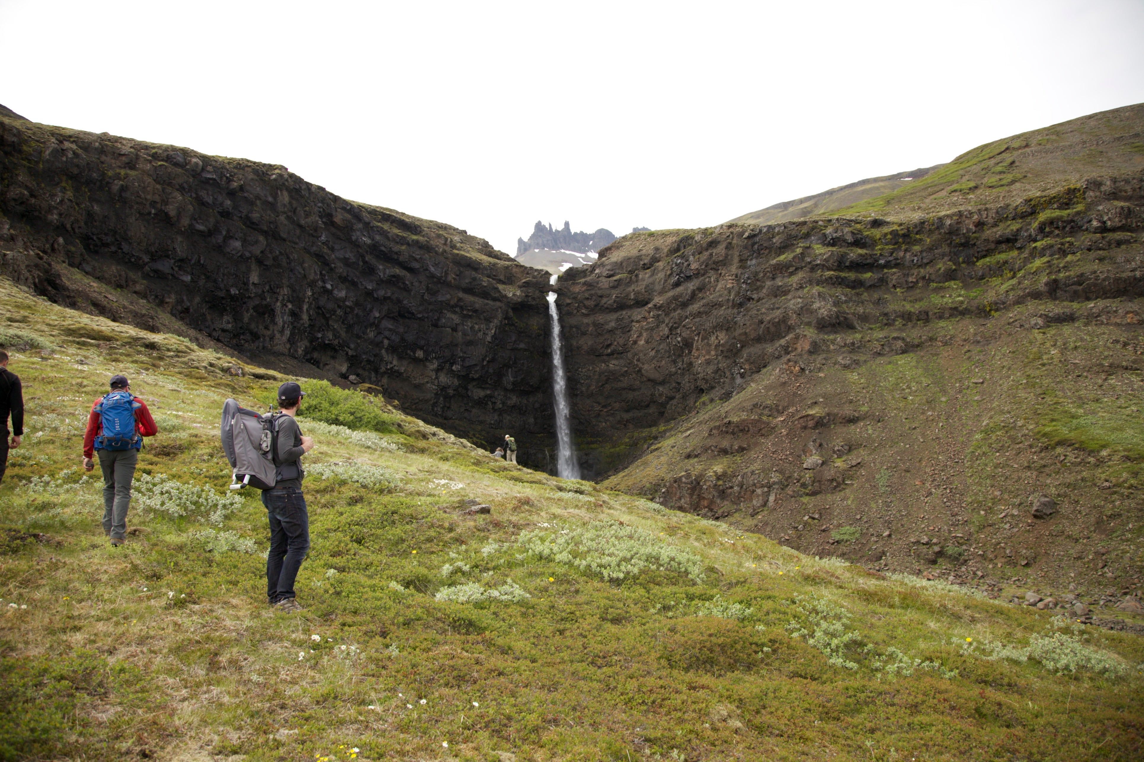 Hikers marveling at the Flogufoss waterfall. 
