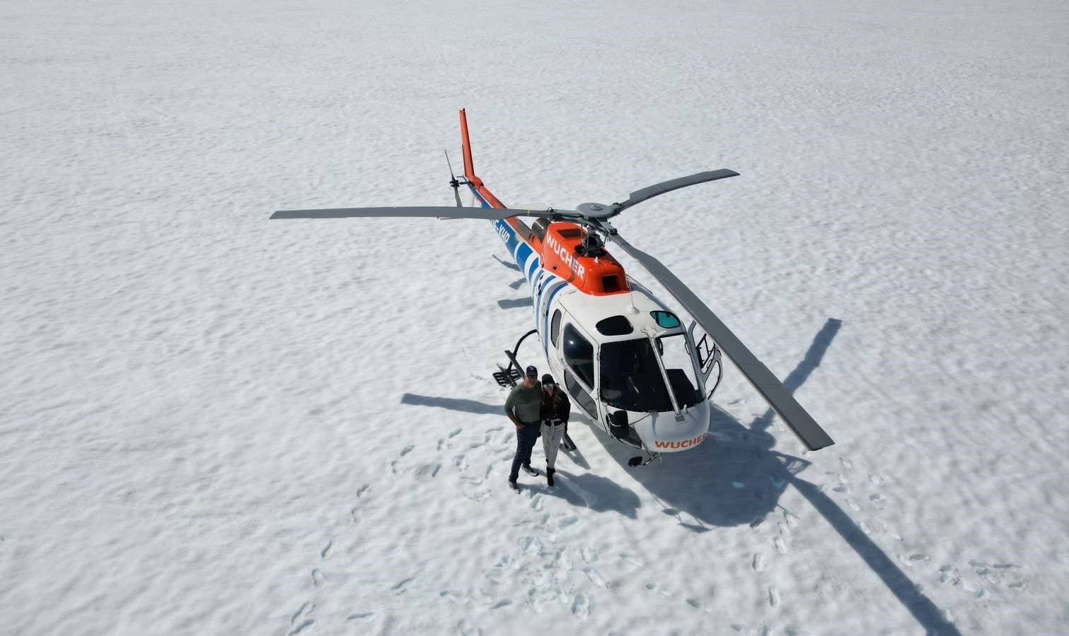 Two travelers posing for a photo while exploring a glacier in West Iceland.