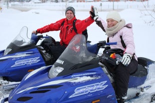 Two people high five on a snowmobiling tour in North Iceland.