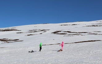 Zwei Leute ziehen Schlitten auf einer Tour in Nordisland.
