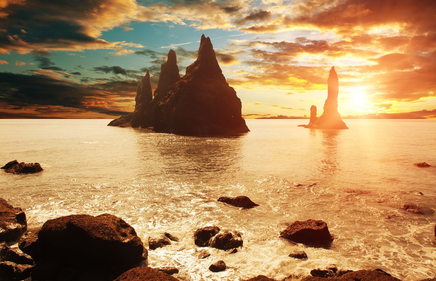 Sommerlicher Sonnenuntergang an den Felsvorsprüngen von Reynisdrangar an der isländischen Südküste.
