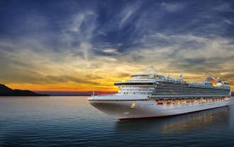A cruise ship sailing on the sea during sunset.