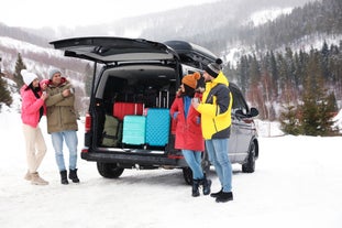 A group of travelers standing beside a minivan for a private transfer service from Reykjavik to KEF Airport.