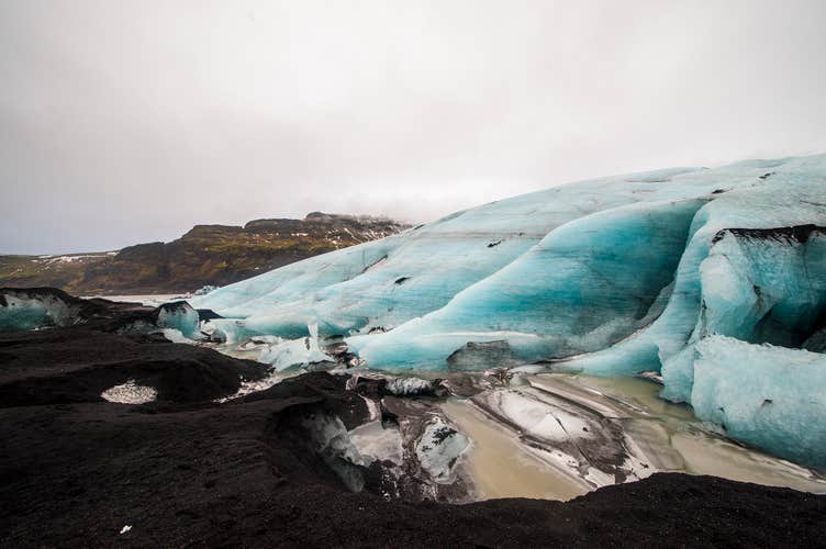 The roots of a glacier, crawling from the highlands to the black sands below, often forming lagoons of ice and meltwater.