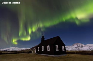 Het noorderlicht dat boven de kerk Búðakirkja op het schiereiland Snæfellsnes in West-IJsland danst.