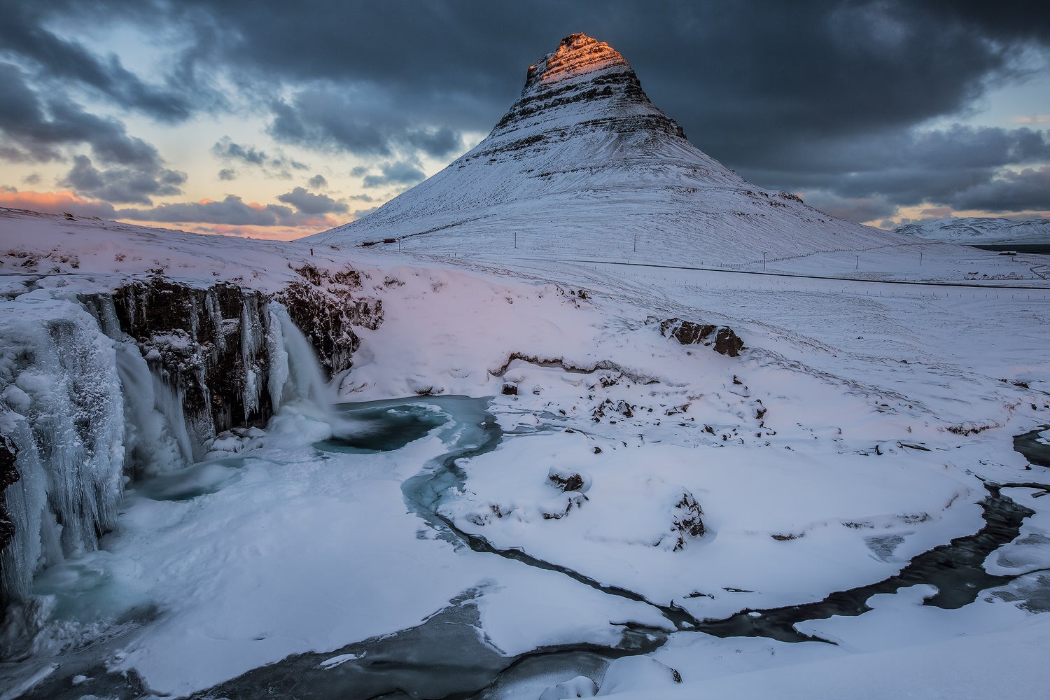 Der Kirkjufell, einer der meistfotografierten Berge Islands, ist in den Wintermonaten von Schnee bedeckt.