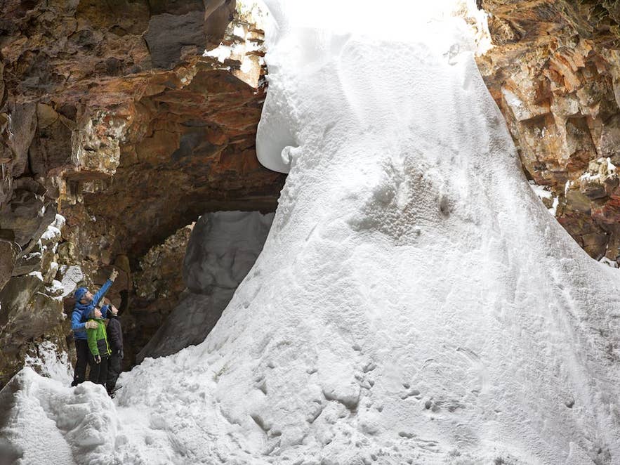 Visitatori esplorano una grotta lavica piena di neve, una delle attività più emozionanti in Islanda a febbraio
