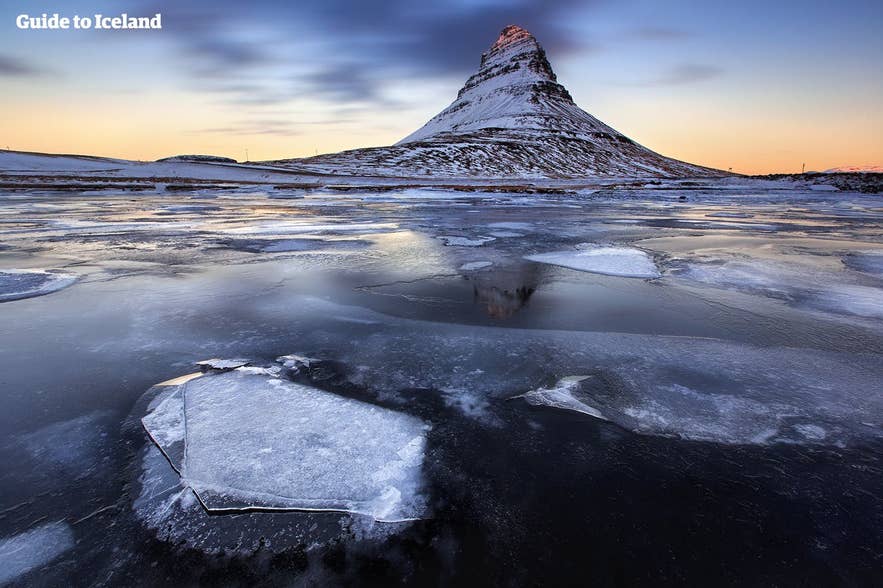 Bevroren landschap rond Kirkjufell bij zonsopgang, een prachtig winters tafereel en een van de meest iconische bezienswaardigheden in februari in IJsland