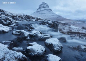 El Monte Kirkjufell, de pie junto a la península de Snæfellsnes, adquiere un aspecto llamativo cubierto de nieve durante el invierno islandés.