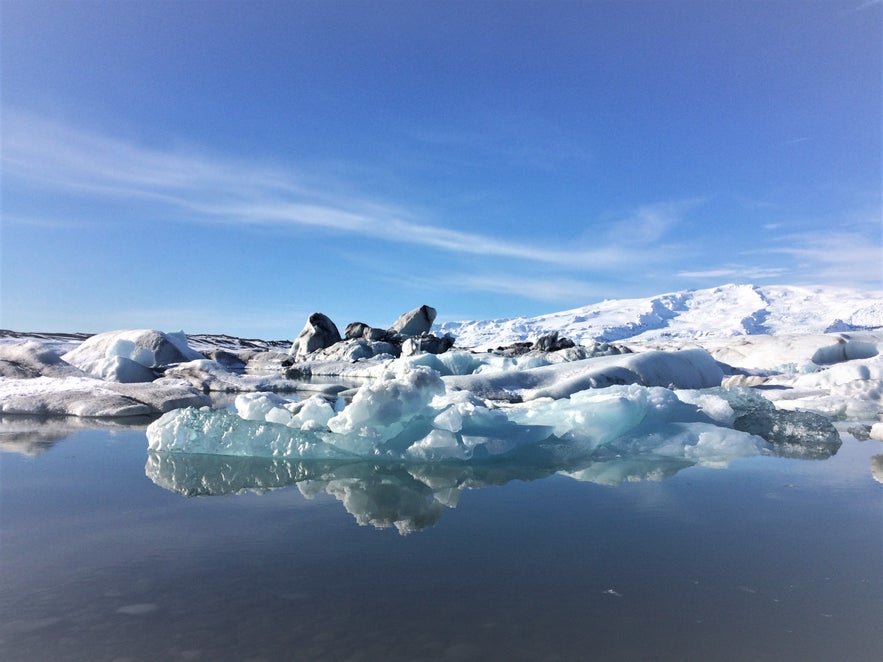 Die Eisberge in JÃ¶kulsÃ¡rlÃ³n sind weiÃŸ, blau und schwarz gefÃ¤rbt