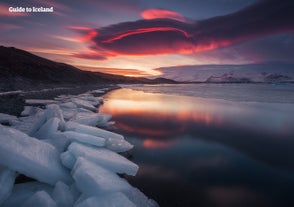 Den røde kveldshimmelen gjenspeilet i den rolige bresjøen Jokulsarlon.