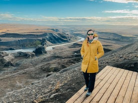 Eine Person posiert für ein Foto mit den atemberaubenden Landschaften von Nordisland im Hintergrund.