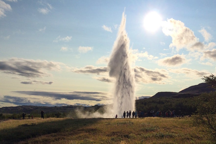 Tourists watch Strokkur erupt under the bright summer sun at the Geysir Geothermal Area in Iceland’s Golden Circle.