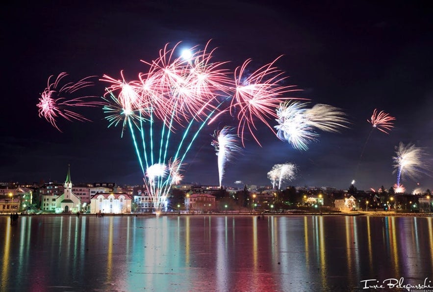 Vy över nyårsfyrverkerier från Tjörnin i Reykjavík