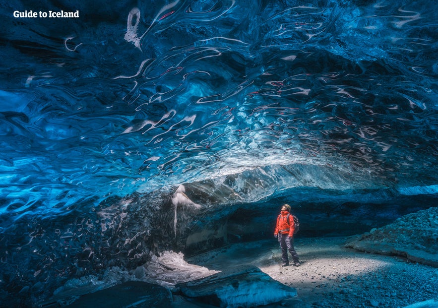 Traveler inside a blue ice cave in Vatnajokull Glacier, highlighting guided safety tips for how to travel in Iceland.