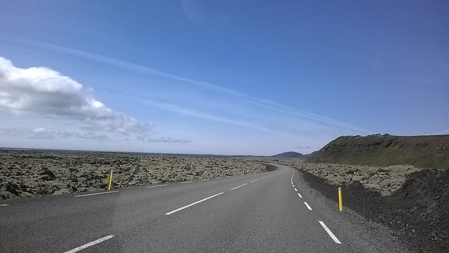 A road cuts through the moss-coated Ögmundarhraun lava field.