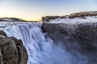 A view of Dettifoss waterfall with its breath-taking fall from up close during sunset.