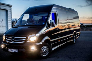 A large sprinter van waits for travelers at Keflavik International Airport.