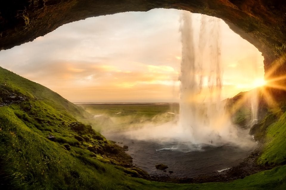 A unique perspective standing behind a stunning South Coast waterfall with a view of its picturesque natural surroundings.