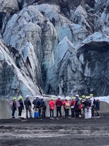 Guests gather around to witness the beauty of Solheimajokull glacier up close.