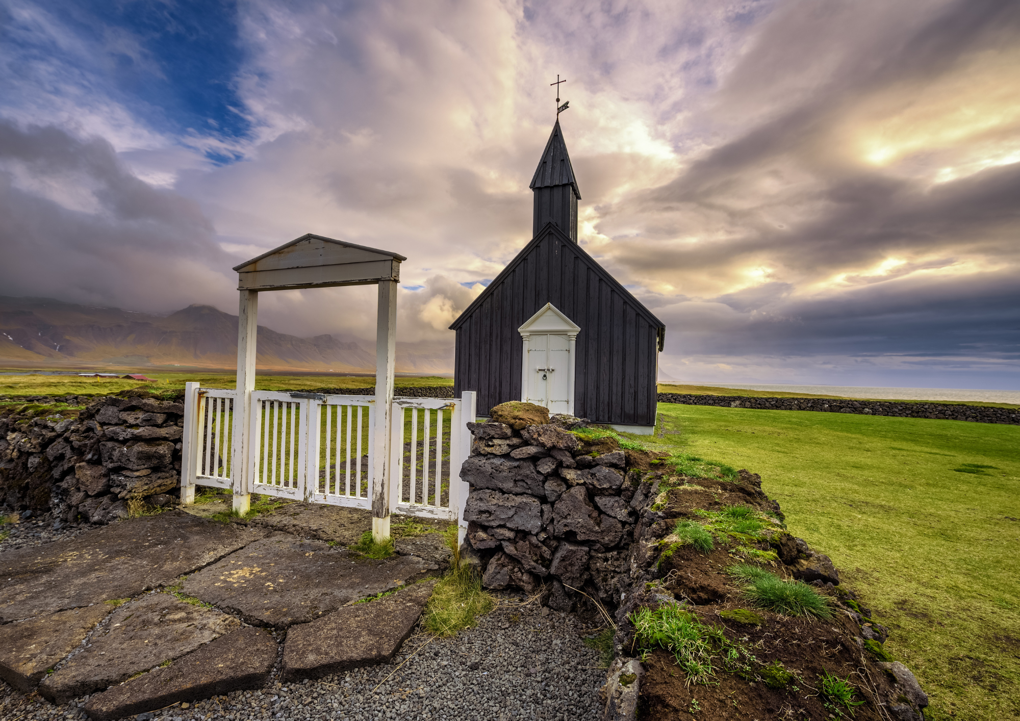 The Budir Black Church with white trim beneath dramatic skies on the Snaefellsnes Peninsula.