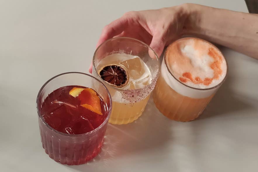 Три ярких коктейля в Litli Barinn, украшенные сушёными цитрусами, пеной и долькой апельсина.