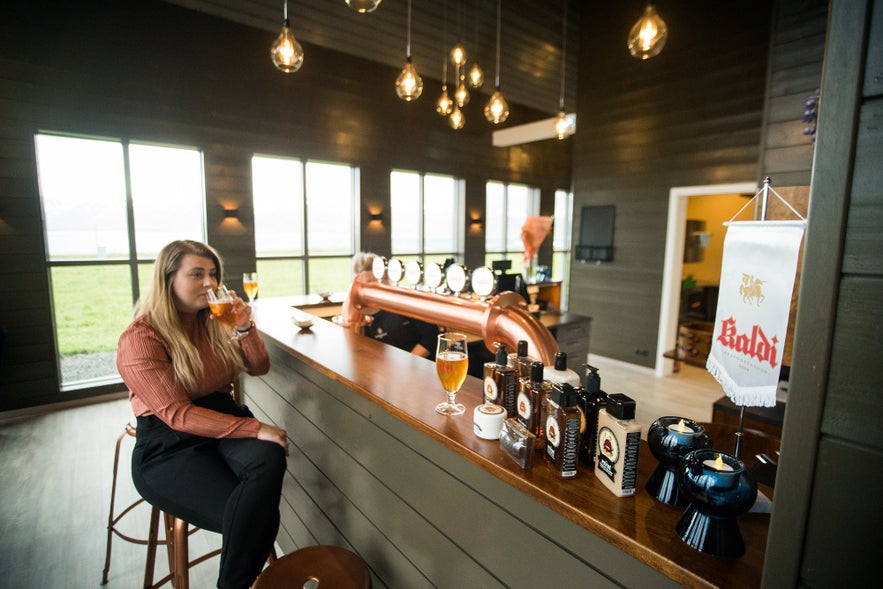 Visitor tasting beers in Iceland at Kaldi Brewery bar in North Iceland.