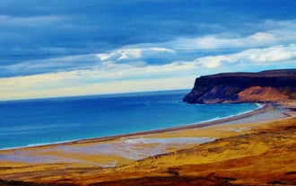 Le bleu de l'océan contraste avec les plages oranges de Raudasandur dans les Fjords de l'Ouest.