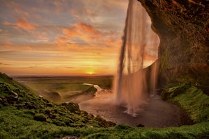 Seljalandsfoss sur la côte sud de l'Islande baignée dans la lumière d'un autre monde du soleil de minuit.