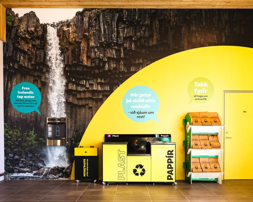 Recycling bins and free tap water station inside Kronan, showing eco-friendly design in grocery stores in Iceland.