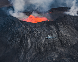 Et helikopter får god oversikt over den boblende lavaen ved utbruddsstedet på Reykjanes.