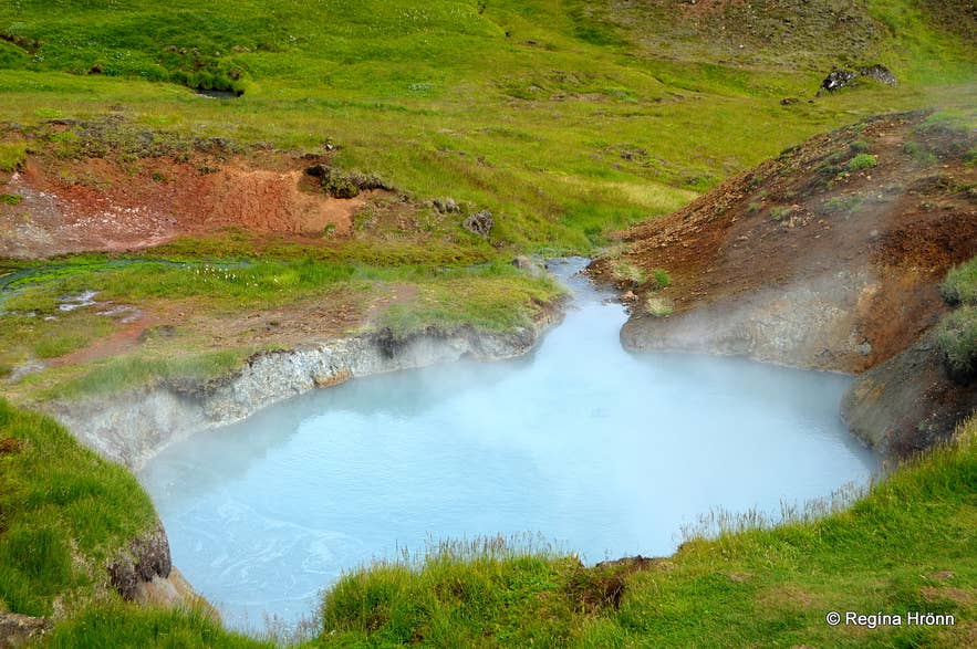Steaming milky blue geothermal pool at Reykjadalur hot spring valley in Iceland.