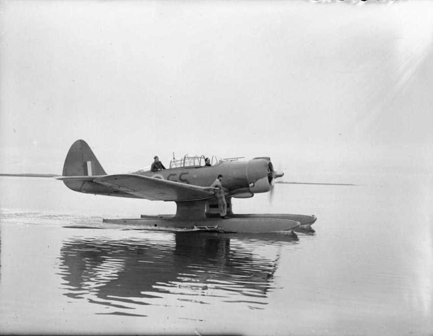 A Northrop N3P-B aircraft, floating in the water at Akureyri, October 1941. An engineer stands on the plane, ready to check its engines.