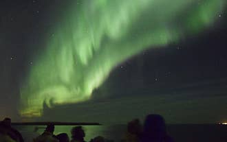 Se det dansende aurora borealis lyse op på aftenhimlen.