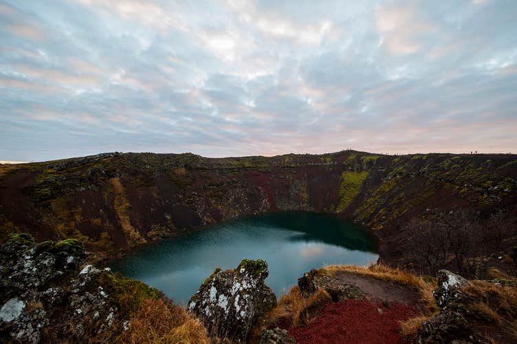 Découvrez les parois rouges et l'eau turquoise du lac de cratère Kerið lors de cette excursion en minibus du Cercle d'Or.