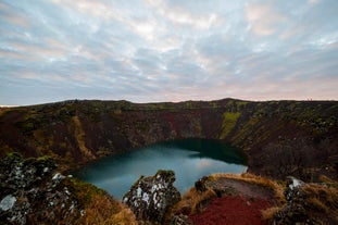 Découvrez les parois rouges et l'eau turquoise du lac de cratère Kerið lors de cette excursion en minibus du Cercle d'Or.