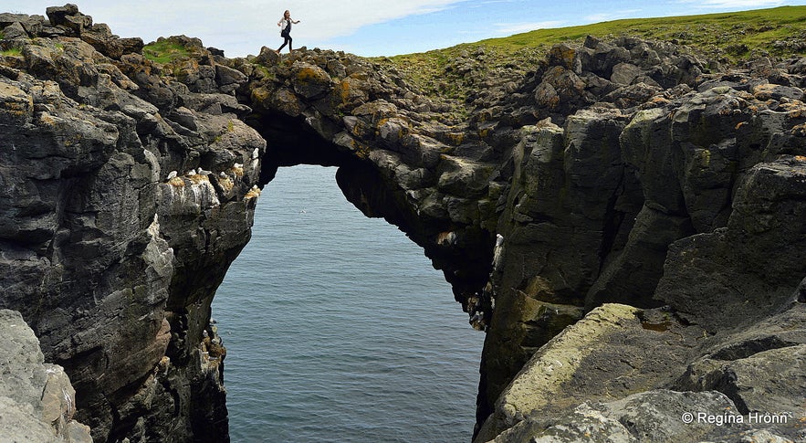 Regína walking on the stone bridge in Arnarstapi Snæfellsnes