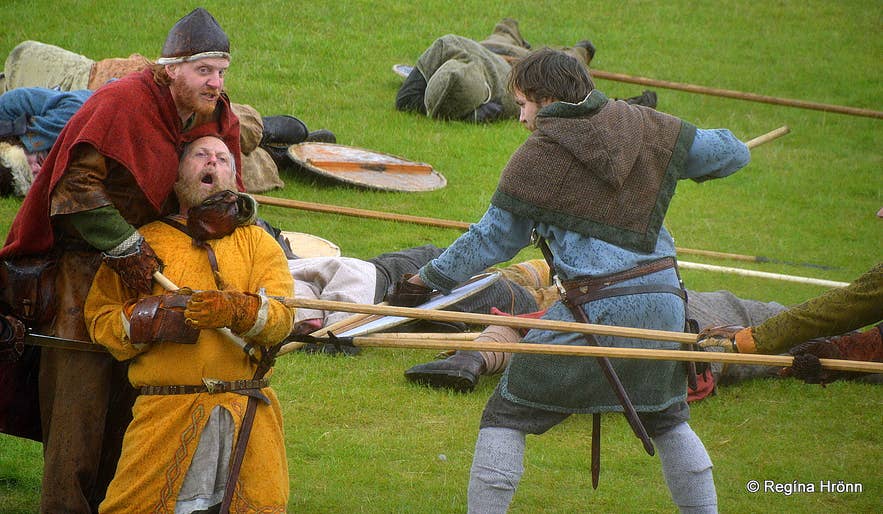 Männer in mittelalterlicher Kleidung stellen eine Kampfszene aus der isländischen Geschichte während eines Wikingerfestivals nach.