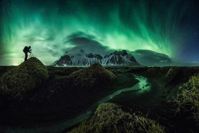 Der Berg Vestrahorn im Winter mit darüber tanzenden Nordlichter