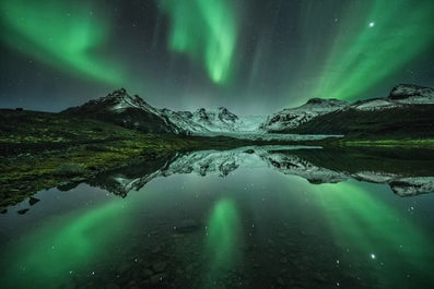 Die Aurora, die sich in einer kalten Winternacht in einem See spiegelt