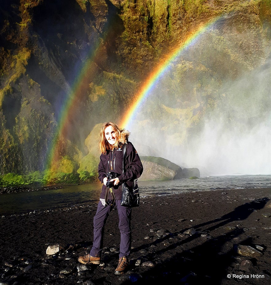 Regína and a rainbow at Skógafoss Waterfall in South-Iceland