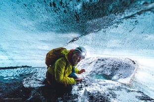 A traveller beams a smile while exploring an ice cave in south iceland