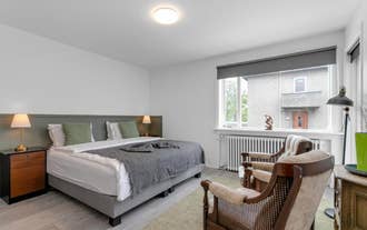 A double room with a large bed and two chairs at Floki by Guesthouse Reykjavik.