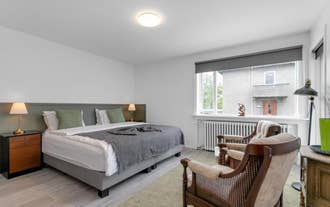 A double room with a large bed and two chairs at Floki by Guesthouse Reykjavik.