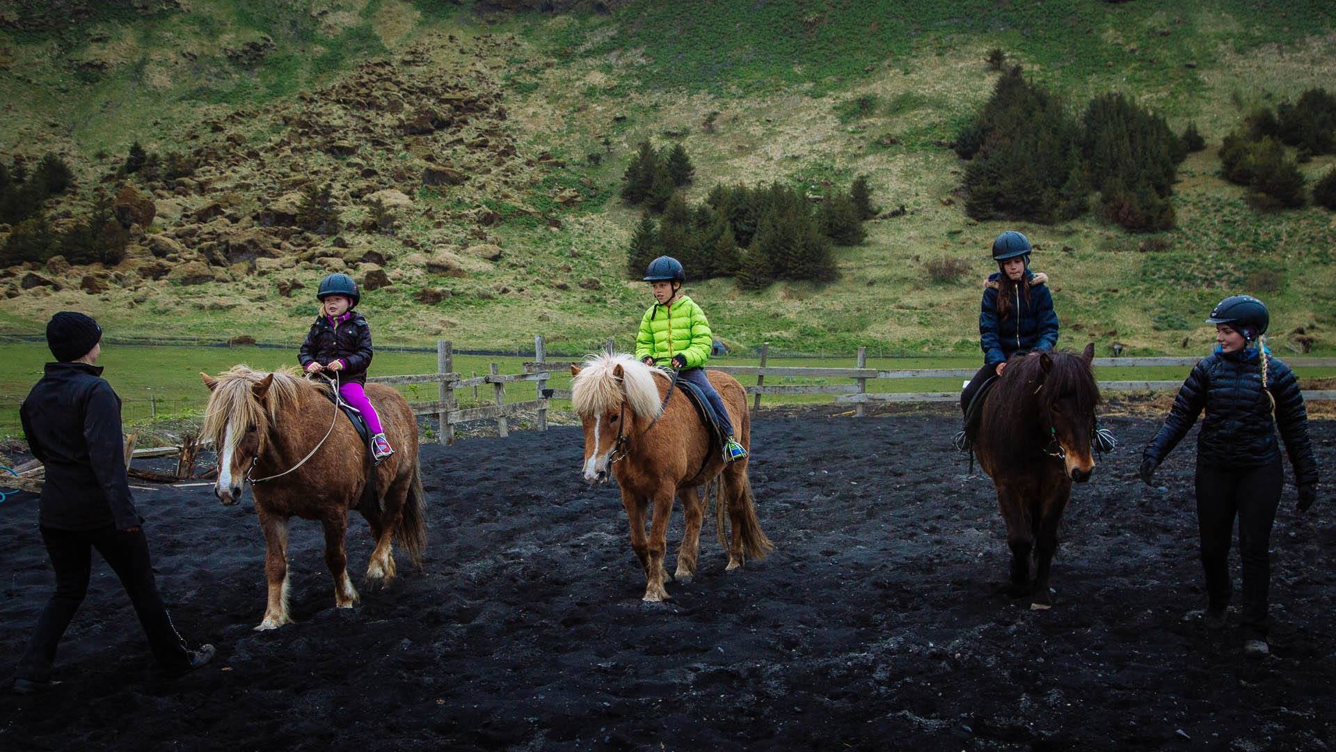 Young riders learning how to ride a horse near Vík on the South Coast of Iceland.